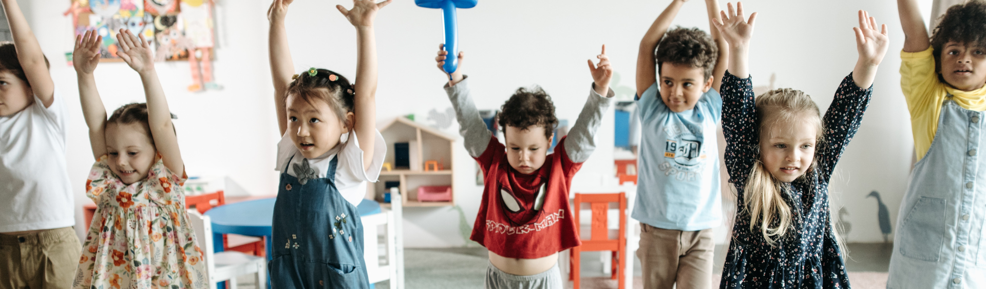 Image of children playing with their arms up in the air